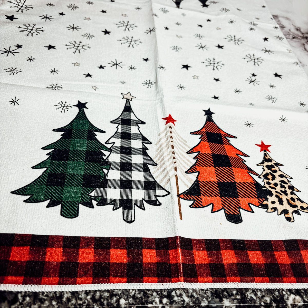 Rustic kitchen towel with red black gingham edges and playful leopard print tree
Christmas towel set with assorted gingham tree designs and snowflakes
Festive holiday towel with red black gingham and assorted colorful Christmas tree patterns