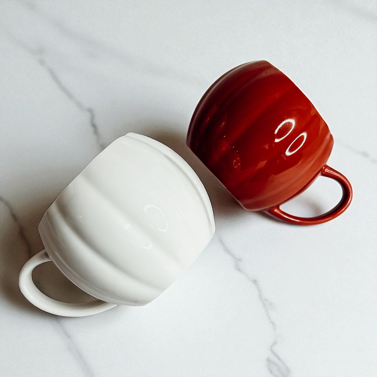 Fall season pumpkin shaped mugs - handcrafted ceramic drinkware for kitchen styling
Orange and white ceramic pumpkin cups - autumn home decor coffee accessories