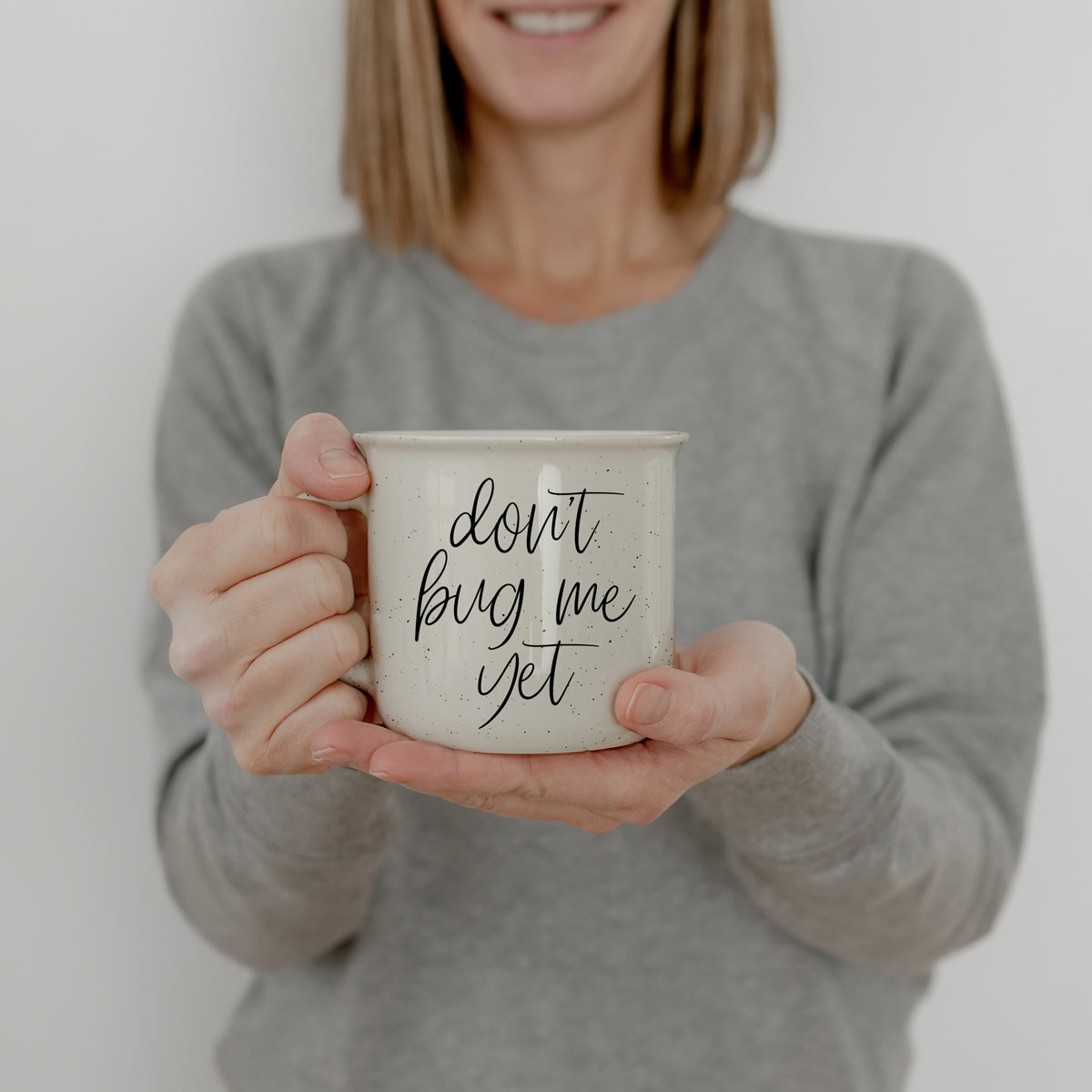 Speckled white ceramic mug with morning humor quote